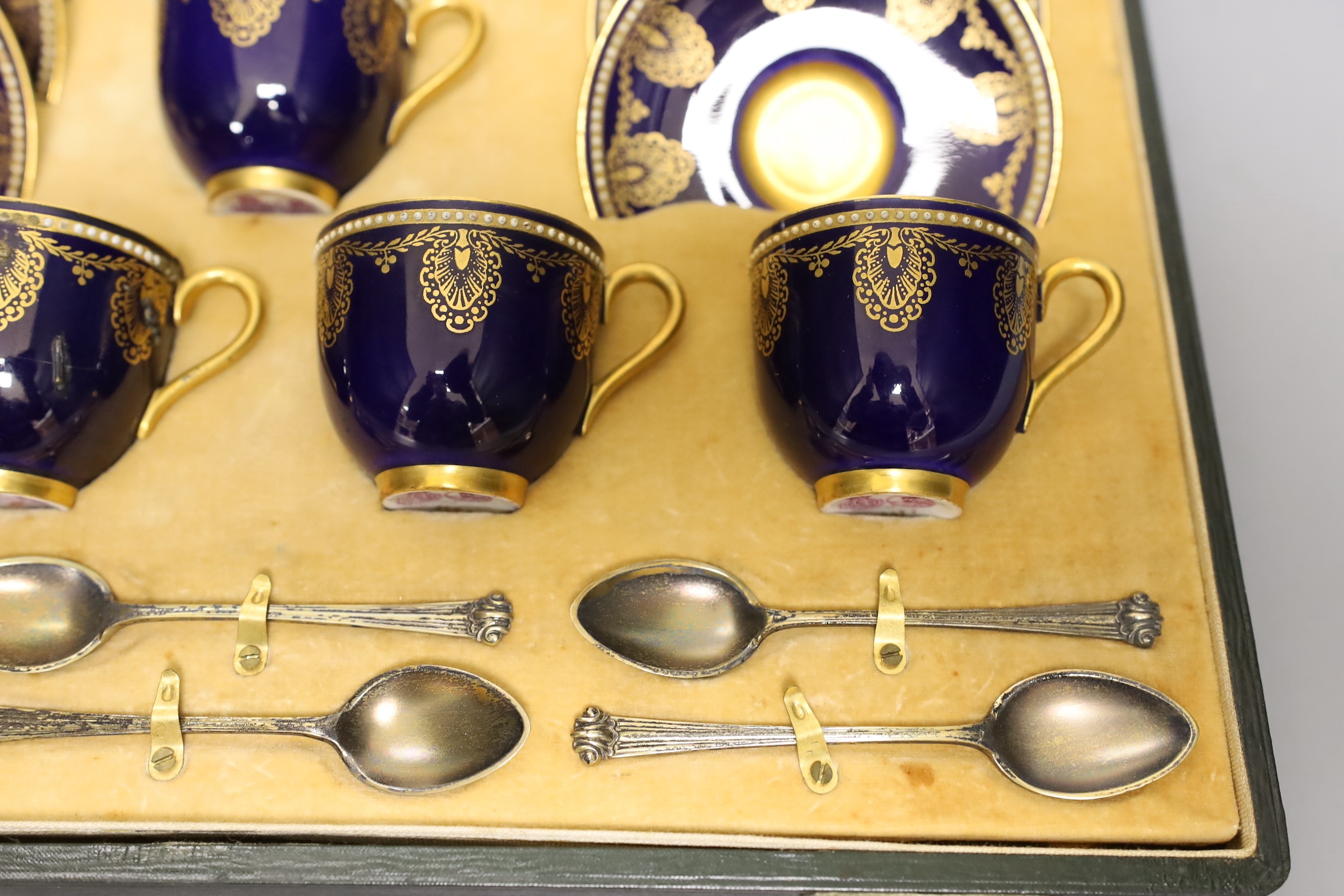 Boxed Royal Worcester blue coffee set with gilt stylised shell and swag design together with six silver coffee spoons; C899 and 6683